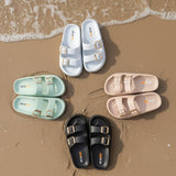 Set of sandals in various colors on a gray floor.