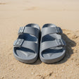 Pair of gray sandals on a tiled floor