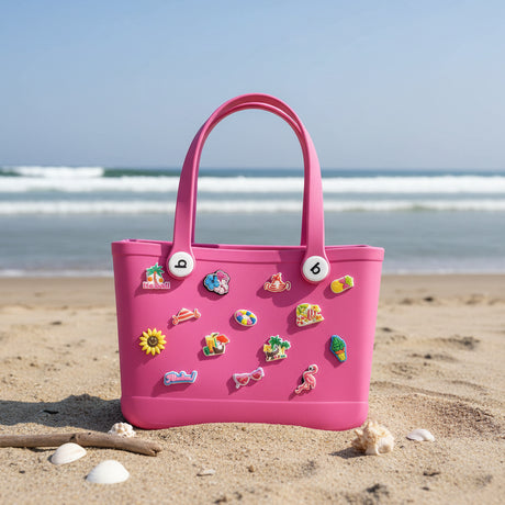 Pink children's crocs bag with colorful pins on the sand