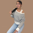 Black and white striped off shoulder knit top layered over a cream cut out tank
