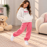 Girl in a white BFF hoodie and hot pink joggers standing on a cream rug