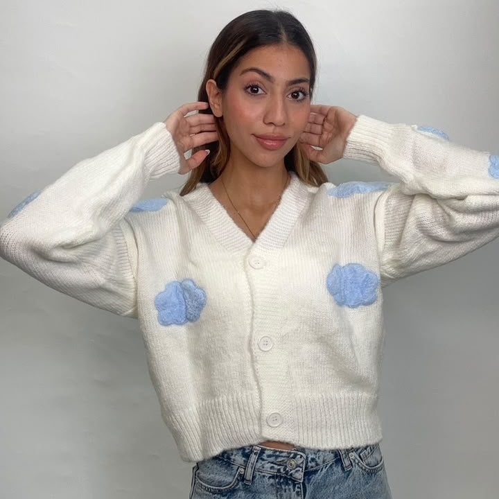 Close view of a white cloud cardigan with soft blue 3D cloud details