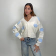 Ivory V neck button cardigan with puffy blue clouds, hands on hips