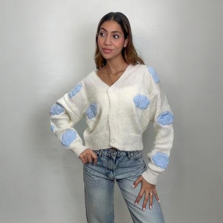Ivory V neck button cardigan with puffy blue clouds, hands on hips