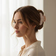 Pale pink bow print claw clip holding a soft twisted updo