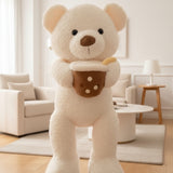 Cream white curly teddy bear holding a brown boba cup plush, shown close up