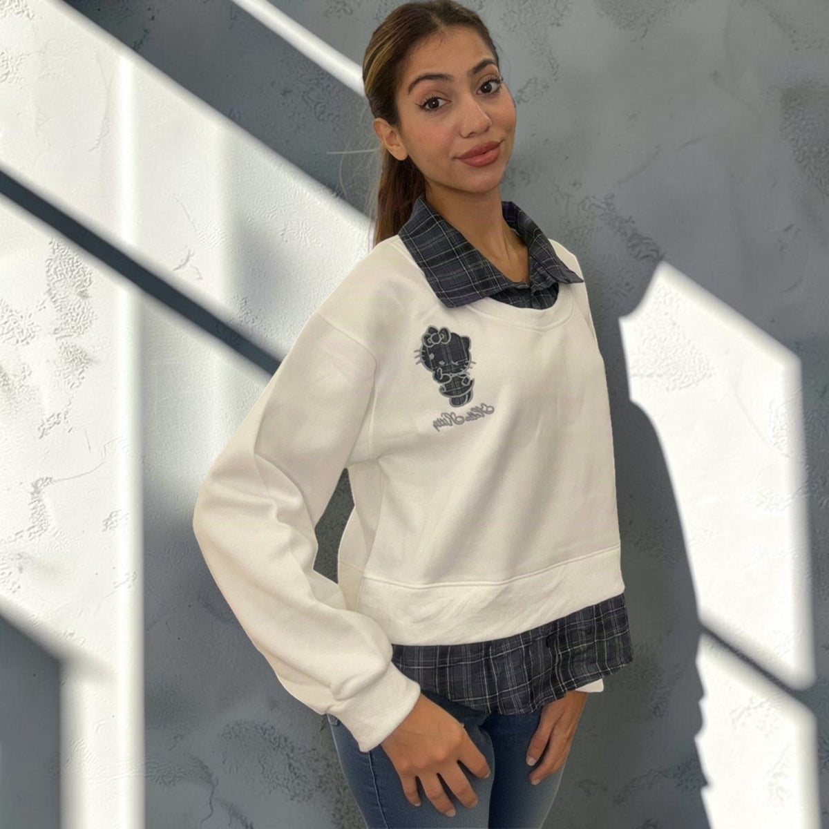 Cream white sweatshirt seen at an angle, showing the dropped shoulder and side seam