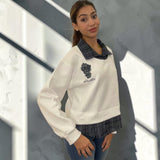 Cream white sweatshirt seen at an angle, showing the dropped shoulder and side seam
