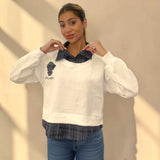 Both points of the check collar held up against a white brushed fleece sweatshirt