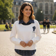 Woman wearing a white check collar sweatshirt in a sunny plaza