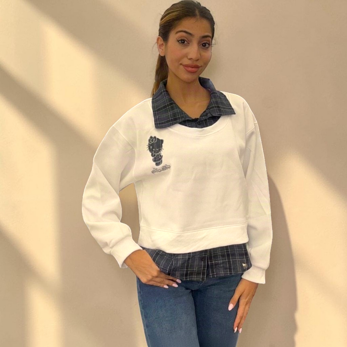 White check collar sweatshirt in sunlight with a small embroidered motif on the chest
