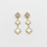 Gold and white clover-shaped earrings on a background