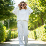 Relaxed white set on a garden path, joggers cropped at the ankle