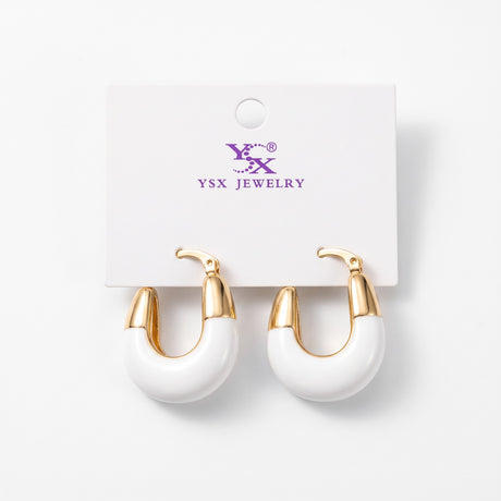 Chunky white enamel hoop earrings with polished gold tone tops on a card