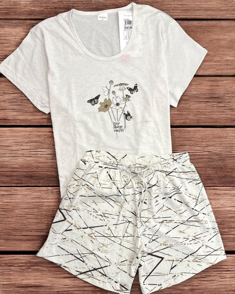 White t-shirt and shorts pyjama set with nature-themed design on a wooden surface