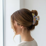 Cream floral claw clip in loose waves, close side view of the print