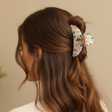 Cream garden print claw clip holding a half up twist, soft daylight