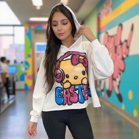 Person wearing a white hoodie with a colorful graphic design of Hello Kitty in a school hallway