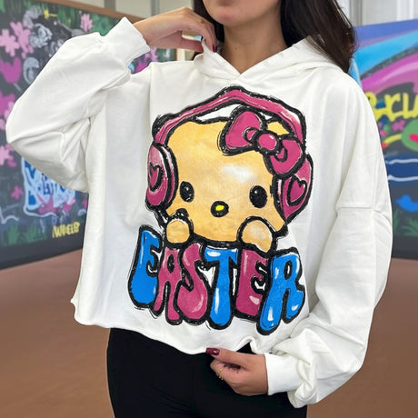 Person wearing a white hoodie with a colorful Easter design in front of a colorful wall