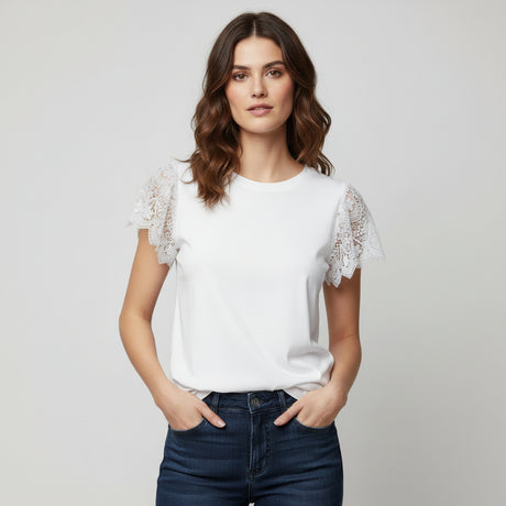 Woman wearing a white blouse with lace sleeves and blue jeans on a plain background