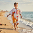 Boy running on the beach in a white Lion King hooded poncho towel with grey pinstripes