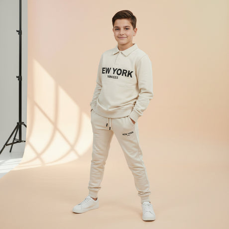 Cream two piece collar sweatshirt and jogger set worn by a boy on a studio backdrop