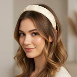 Cream padded headband worn with loose waves, soft ruched satin finish