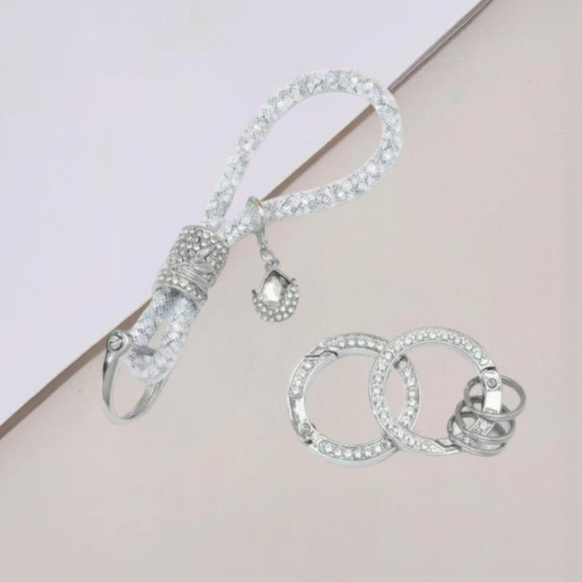 Clear crystal keychain strap beside two spare rings, a cut glass teardrop at the clasp