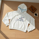 Close view of the navy script lettering and red dots on white brushed fleece