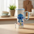 Cream Stitch tumbler with a powder blue handle and lid on a kitchen counter