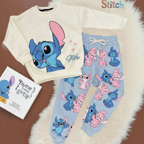 Cream crewneck top and blue drawstring joggers with a pink and blue character print laid flat