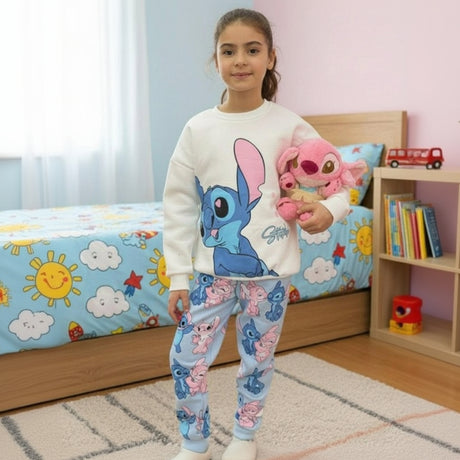 Child in a cream and pale blue two piece lounge set holding a pink plush toy