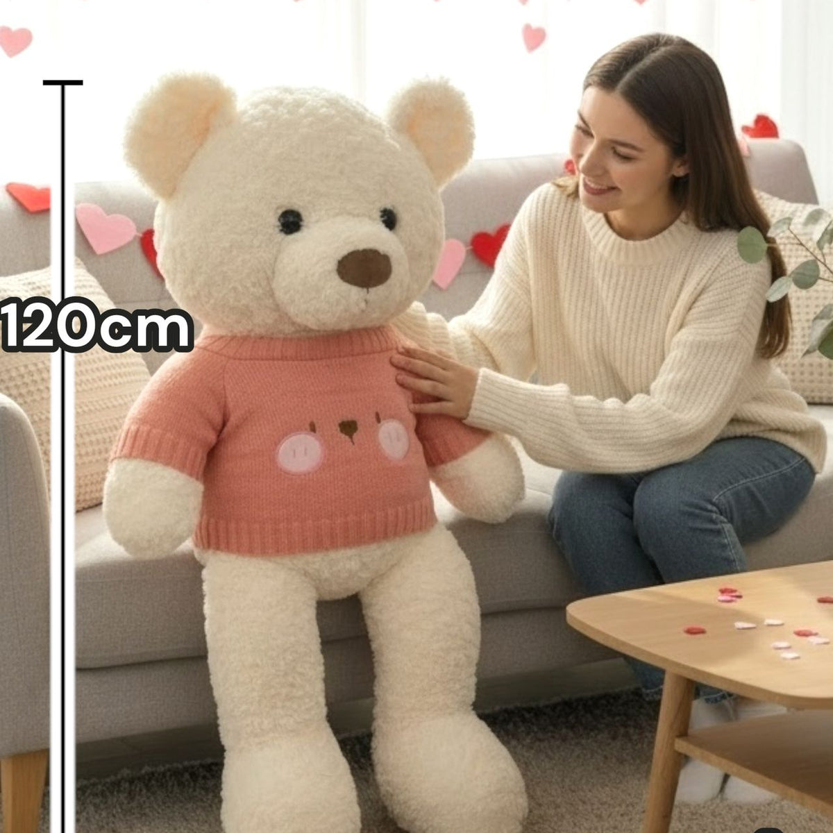 Cream curly teddy bear in a dusty rose ribbed knit jumper beside a 120cm line