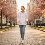 White zip hoodie worn zipped with hands in the pockets on a blossom lined street