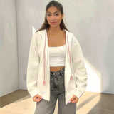 Oversized white zip hoodie jacket with pink braided drawstrings and tassel ends