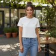 Woman wearing a white crop top with blue trim oudoors