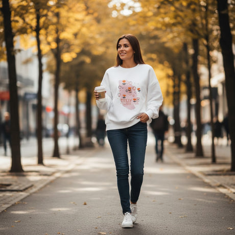 Woman walking a tree lined avenue in a white tulip print sweatshirt with jeans