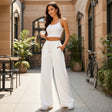 White wide leg sweatpants worn outside a cafe with white trainers