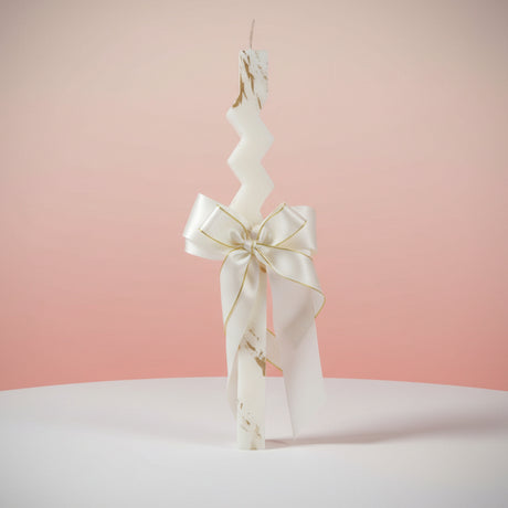White marbled zigzag candle with a cream satin bow