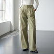 Woman wearing a white top and wide-leg pants in a minimalistic room