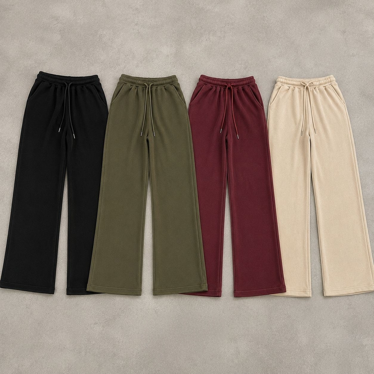 Four pairs of wide leg sweatpants laid flat in black, olive, burgundy and beige