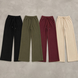 Four pairs of wide leg sweatpants laid flat in black, olive, burgundy and beige