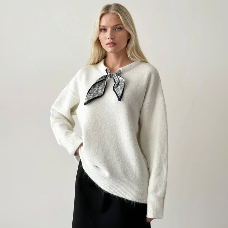 White fluffy jumper with a black and silver print scarf knotted at the collar