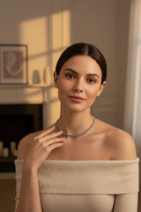Woman wearing a double necklace in a softly lit room