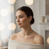 Woman wearing a black necklace in a softly lit room