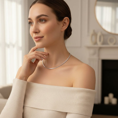 Woman wearing a silver necklace in a softly lit room