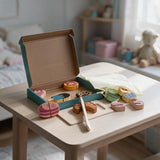 Ice cream and dessert cutting set with wooden donuts, cake and croissant pieces beside a board