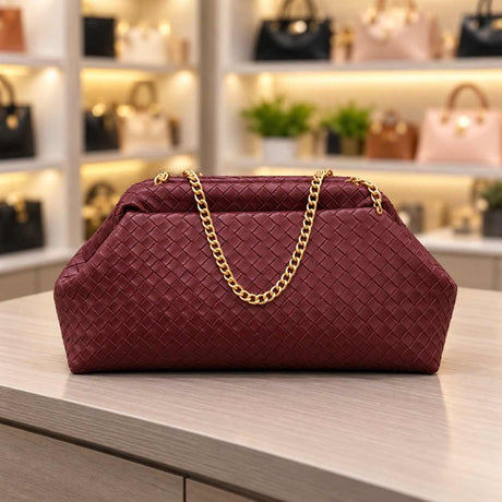 Burgundy woven pouch clutch with a basket weave texture and a gold chain shoulder strap