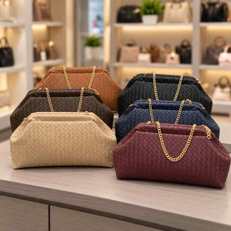 Six woven pouch clutch bags with gold chain straps in camel, black, brown, navy, beige and burgundy on a counter