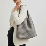 Woman carrying a grey woven shoulder bag, casual daily look